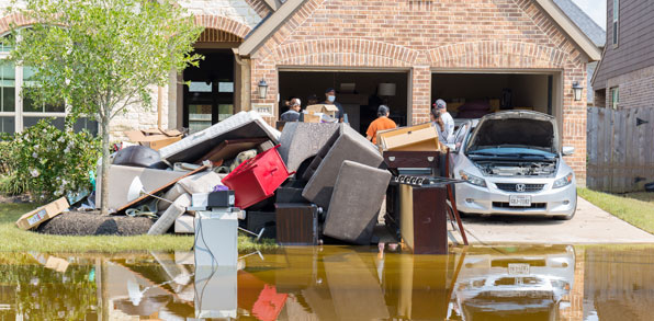 Home in heavy rain and standing water highlighting need for flood insurance
