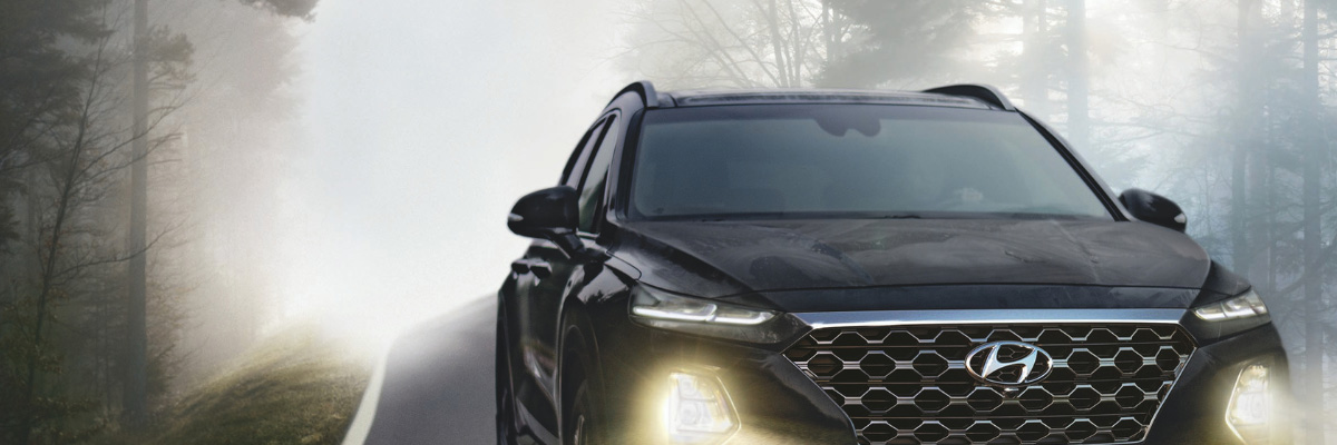 Black Hyundai driving on a foggy road illustrating auto insurance coverage